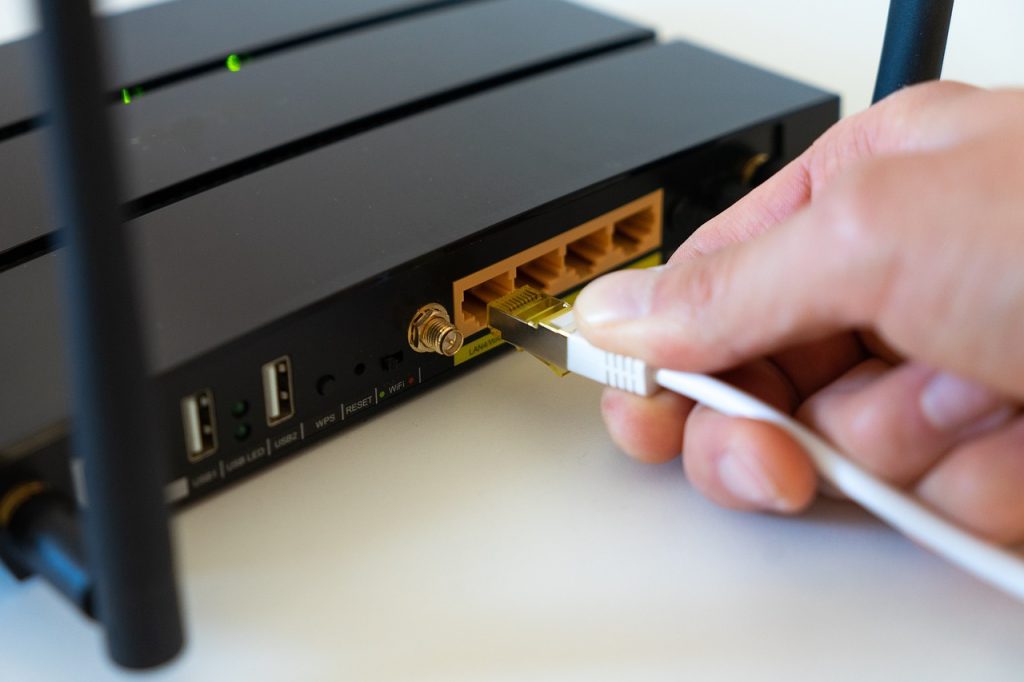 Modem ou roteador com luzes indicadoras piscando, ilustrando problemas comuns de conexão de rede que podem afetar a qualidade do serviço, e gerar um IPTV travando.
