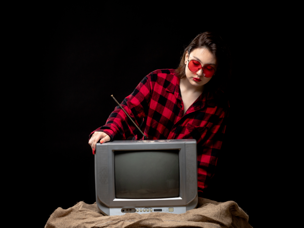 Imagem de uma TV de tubo antiga, indicando que provavelmente é uma TV a cabo, com uma pessoa a segurando.
