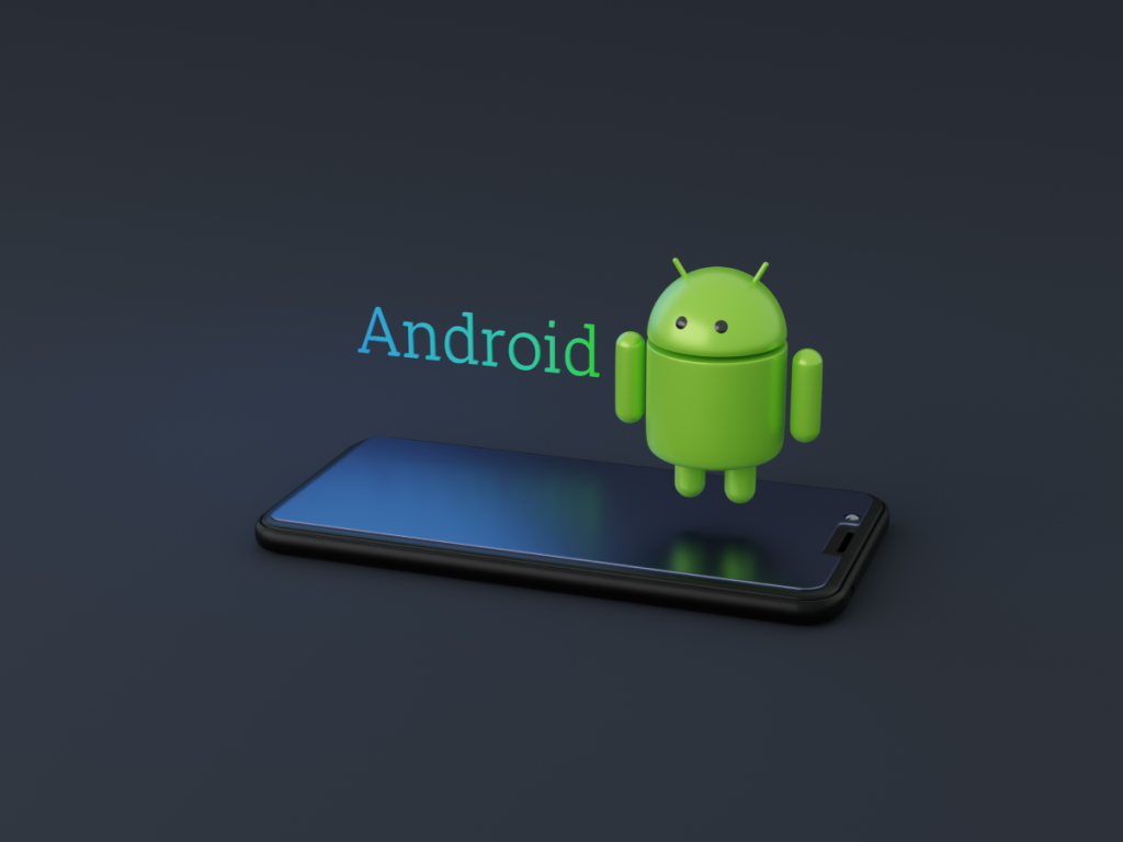 Mascote Android 3D em pé sobre um smartphone preto, com a palavra Android em destaque. Representação do sistema operacional para celulares.