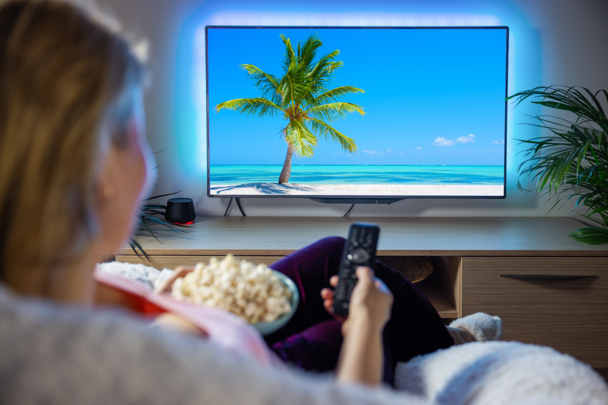 Pessoa assistindo televisão com imagem em alta definição, simbolizando a qualidade visual do IPTV na televisão.