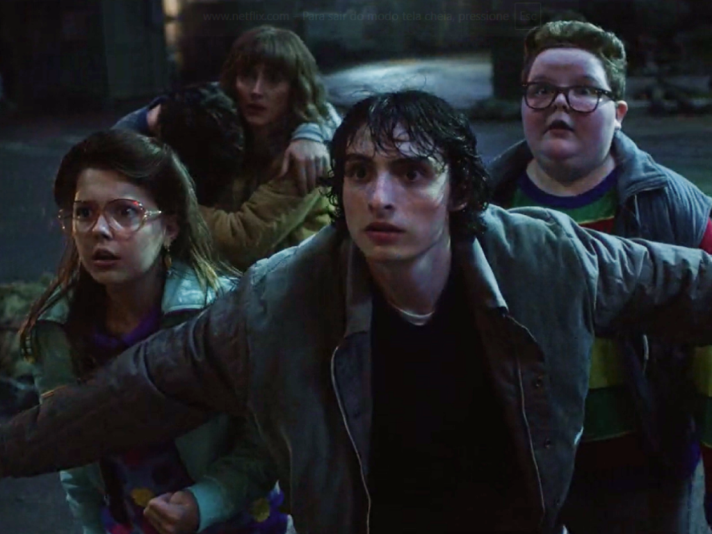 Mike e o grupo de amigos atentos e em posição de defesa durante os eventos sombrios de Stranger Things 5.