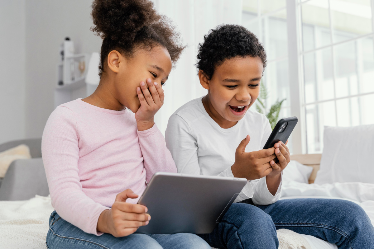 Crianças assistindo a conteúdo digital em um tablet e celular, representando o uso do IPTV com controle parental.