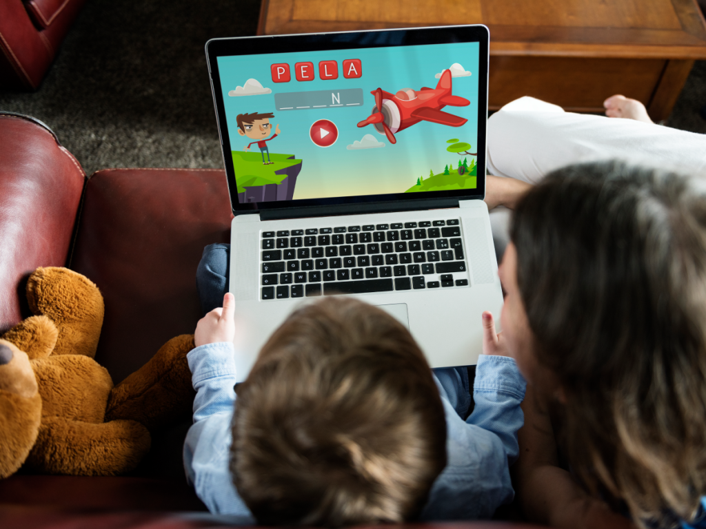 Criança acompanhada de um adulto assistindo a conteúdo educativo em um laptop, representando o uso seguro do IPTV com supervisão dos pais.